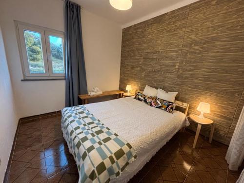 サン・ルイスにあるCasa do Henriqueのベッドと木の壁がある寝室