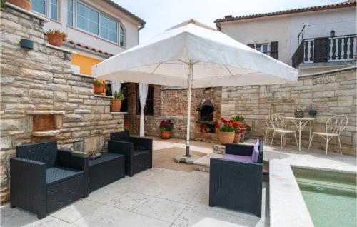 un patio con ombrellone e sedie e una piscina di Holiday Home Kavran Ii a Kavran