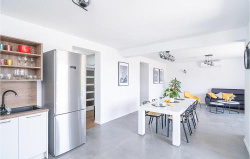 a kitchen and dining room with a white table and chairs at Nice Apartment In Molunat With Wifi in Molunat