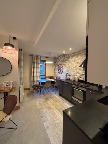 eine Küche und ein Wohnzimmer mit Tisch und Stühlen in der Unterkunft Arc1950 Prince Des Cimes appt 4-5 pers ski in out piscine intérieure in Arc 1950