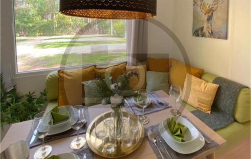 a living room with a couch and a table with wine glasses at Waldcamping Am Brombachsee in Pleinfeld