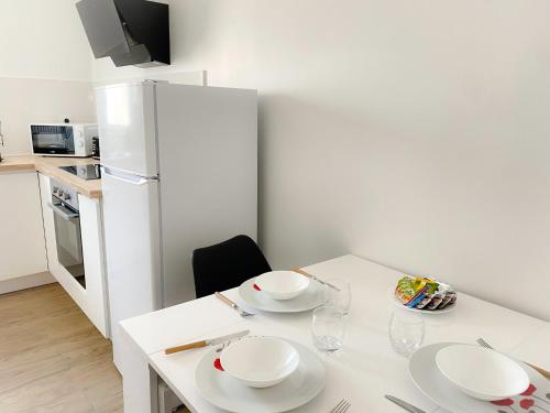 d'une cuisine avec une table blanche et des plaques de cuisson. dans l'établissement Les Dunes 2, à Sangatte