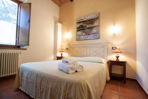 a bedroom with a bed with towels on it at Borgo San Martino - Residence Hotel & SPA in Riparbella