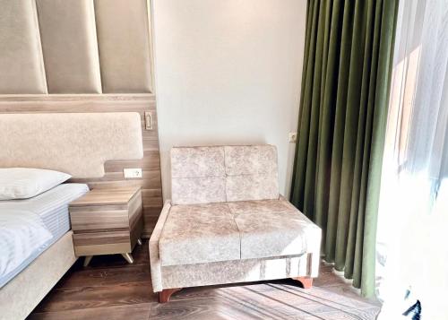 a bedroom with a chair and a bed and a window at Business class studio with the Mountain View 115А in Batumi