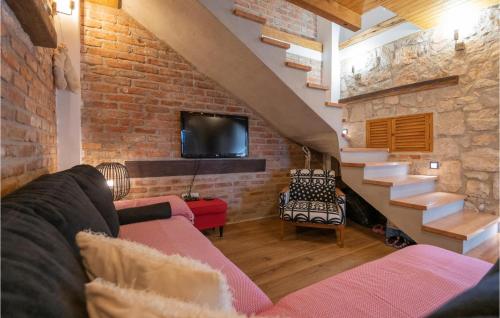 a living room with a couch and a brick wall at Awesome Home In Glavina Donja in Donja Glavina