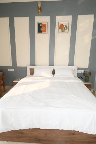 a bedroom with a large white bed with blue walls at shangrila stay in Bodh Gaya