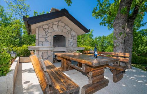 a picnic table with a bird house and a bottle of wine at Lovely Home In Vinjani Gornji in Nenadići
