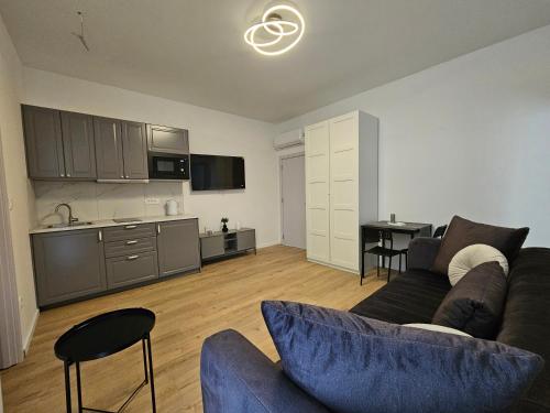 a living room with a couch and a kitchen at Regal Retreats in Zagreb