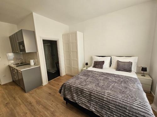 a bedroom with a large bed and a kitchen at Regal Retreats in Zagreb