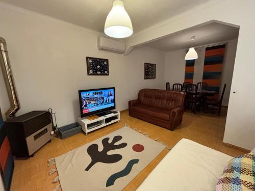 a living room with a couch and a television at Casa do Henrique in São Luis