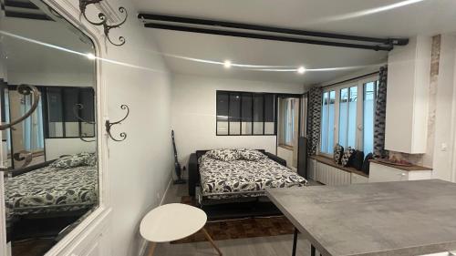 une chambre avec deux lits et une table dans l'établissement Bel Appartement a 5 minutes du Louvre, à Paris