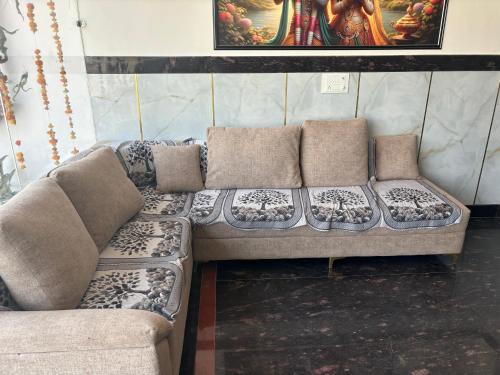 a couch with pillows on it in a room at Hotel Santosh Palace in Khātu
