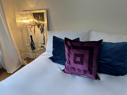 - un lit blanc avec des oreillers bleus et violets et une lampe dans l'établissement Luxury Apartment with a view of the Eiffel Tower, à Paris