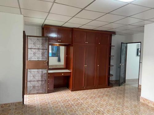 an empty room with a mirror and wooden cabinets at Wonder House in Hat Yai