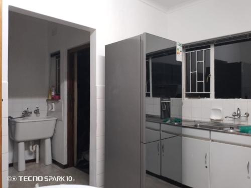 a white bathroom with a sink and a mirror at Cozy Retreat Ferndale in Johannesburg