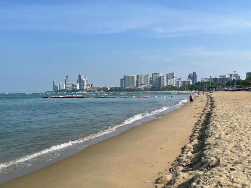 a sandy beach with a city in the background at Edge Central Pattaya By Su in Pattaya Central