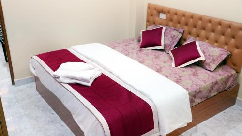 a bedroom with a bed with purple and purple sheets and pillows at Haven Garden Homestay in Port Blair
