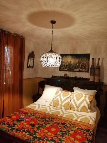 une chambre avec un lit et un lustre dans l'établissement Lou Masou, à Flayosc