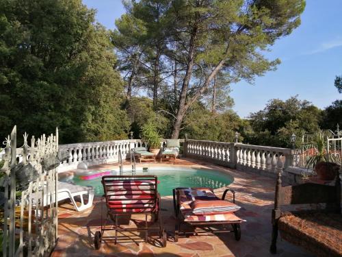 une piscine avec des chaises et une clôture dans l'établissement Lou Masou, à Flayosc