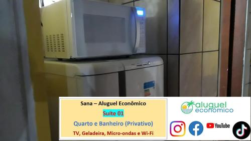 a microwave sitting on top of a refrigerator at Sana - Aluguel Econômico in Sana