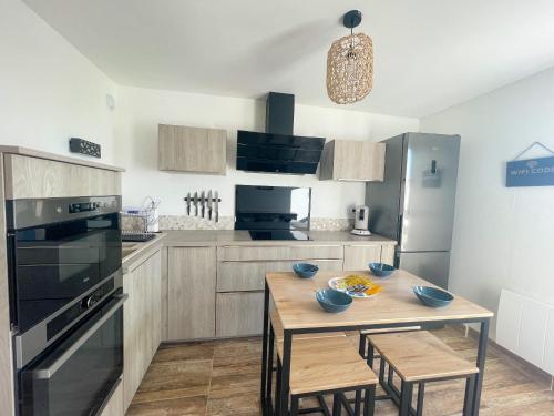 - une cuisine avec une table en bois et un four noir dans l'établissement L'Horizon, à Calais