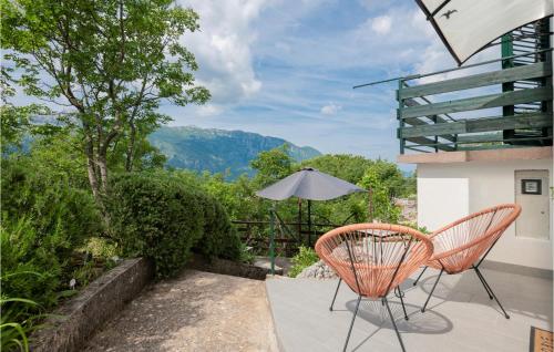 a patio with two chairs and an umbrella at Gorgeous Home In Zagvozd With Wifi in Zagvozd