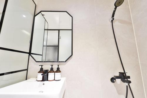 a bathroom with a sink and a mirror at No 25 Hotel Yonghyun in Incheon