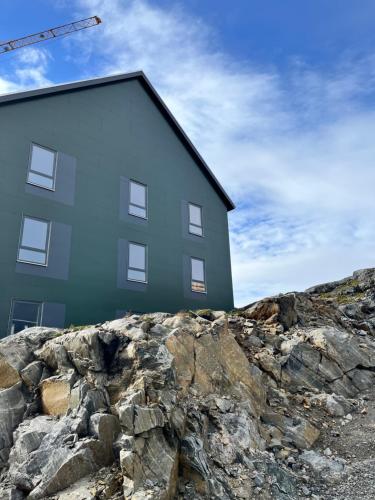 a building on top of a rocky hill at ATCON Business Apartments in Nuuk