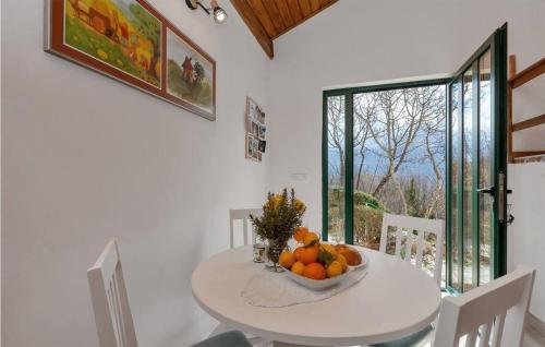a white dining room with a bowl of fruit on a table at Gorgeous Home In Zagvozd With Wifi in Zagvozd