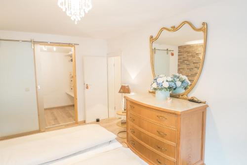 a bedroom with a dresser with a mirror on it at Elas Ferienhaus in Schleiden