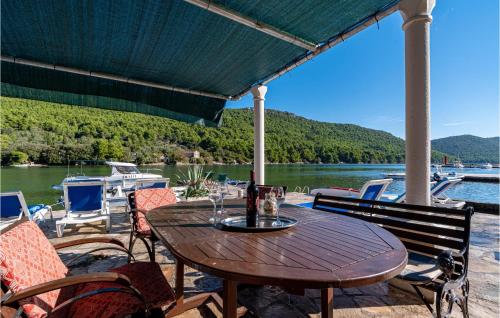 a wooden table on a patio with a view of a lake at Two-Bedroom Apartment In Ston in Ston