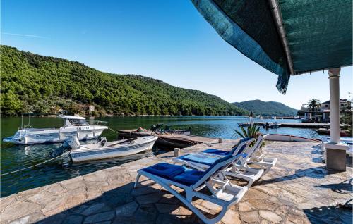 a group of chairs sitting on a dock with boats at Two-Bedroom Apartment In Ston in Ston