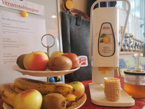 a table with two plates of fruit and a blender at No1 - Flo's Rooms & Breakfast in Wagrain