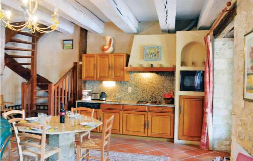 une cuisine avec des armoires en bois et une table avec des chaises dans l'établissement 3 Bedroom Amazing Home In Monestier, à Monestier