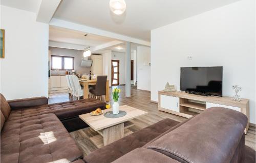 a living room with a large couch and a television at Four-Bedroom Holiday Home In Bilice in Bilice