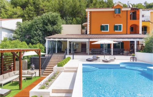 a villa with a swimming pool and a house at Awesome Home In Skradin With Sauna in Skradin
