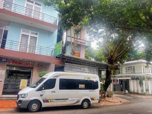 a white van parked in front of a building at Khách Sạn Nam Nguyên in Buon Ma Thuot