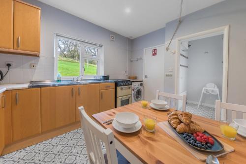 a kitchen with a wooden table with a plate of food on it at Hollace, Lake District bungalow with hot tub and stunning views in Coniston