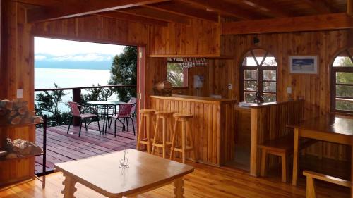 a living room with a deck with a view of the water at Terra Luna Lodge in Puerto Guadal