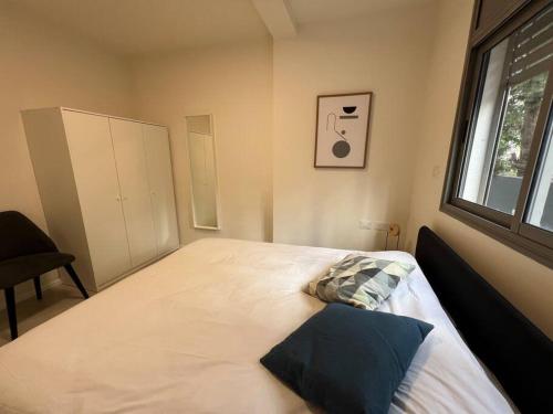 a bedroom with a large white bed with a window at Family Apartment By IsrApart in Ramat Gan