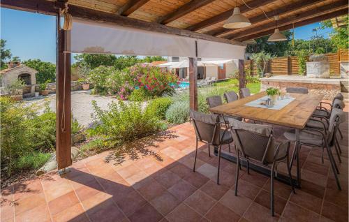 an outdoor patio with a wooden table and chairs at Holiday Home Tinjan 56 in Tinjan
