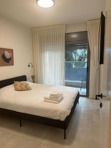 a bedroom with a bed with towels on it at Family Apartment By IsrApart in Ramat Gan