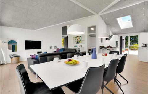a dining room and living room with a white table and chairs at 4 Bedroom Cozy Home In Spøttrup in Spottrup