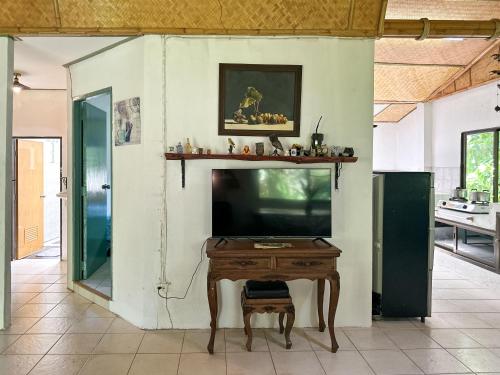 a living room with a tv and a table at Baan Suanthip Homestay - Aoluek Natural Retreat in Ao Luk