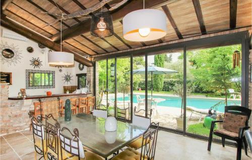 Un comedor con mesa y una piscina. en Beautiful Home In Carpentras, en Carpentras