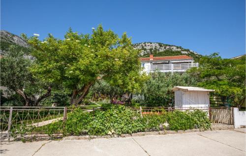 a fence with trees and a building in the background at 3 Bedroom Awesome Apartment In Klek in Klek
