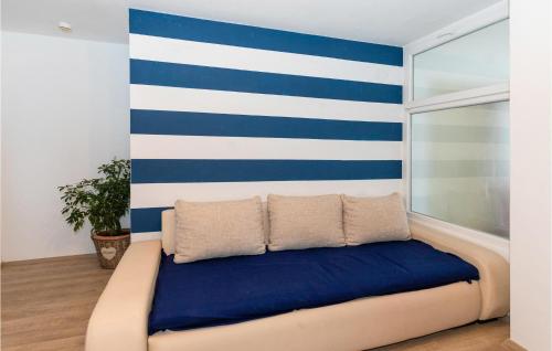 a bed in a room with a blue and white wall at 3 Bedroom Awesome Apartment In Klek in Klek