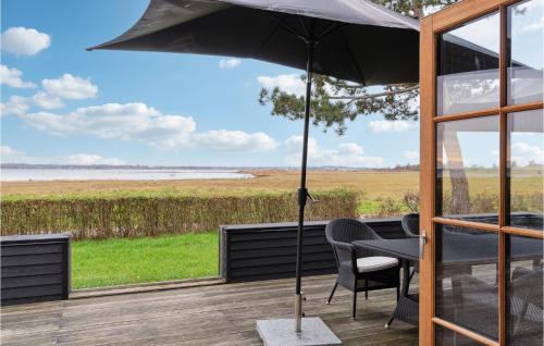 a patio with a table and an umbrella at Holiday Home Tornehagen Holbæk Ii in Holbæk