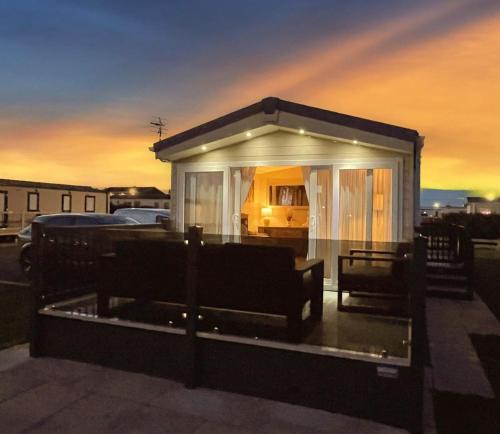 a small white building with a car in it at Golden Palm Resort - The Ascot - Coastal Caravan Breaks in Chapel Saint Leonards
