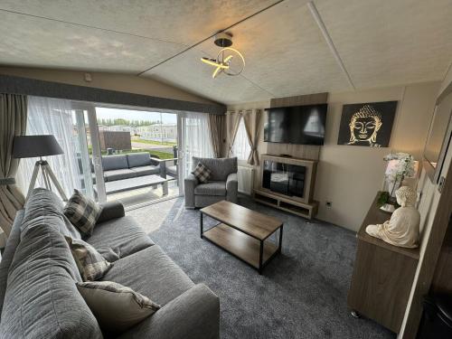 a living room with a couch and a table at Golden Palm Resort - The Ascot - Coastal Caravan Breaks in Chapel Saint Leonards
